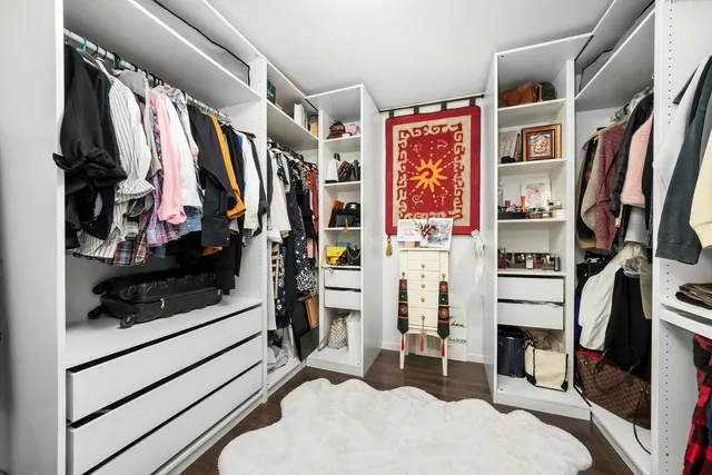 a view of walk in closet with clothes and shoes