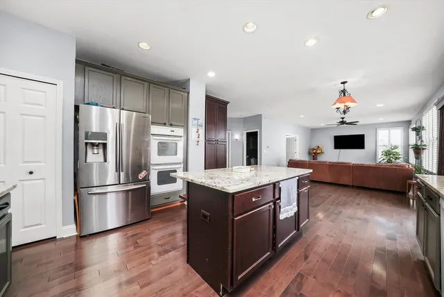 a kitchen with stainless steel appliances granite countertop a refrigerator and a stove