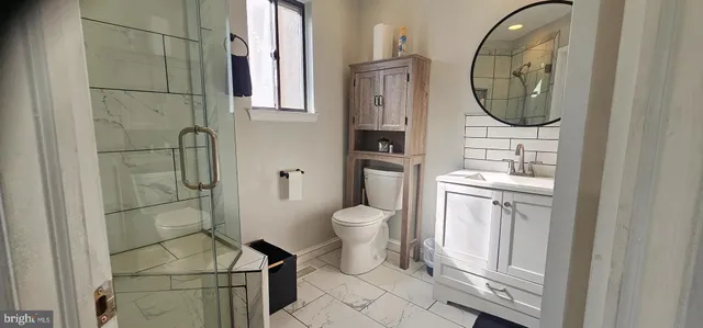 a bathroom with a toilet a sink and a mirror