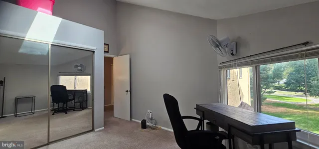 a view of a workspace with furniture and a window