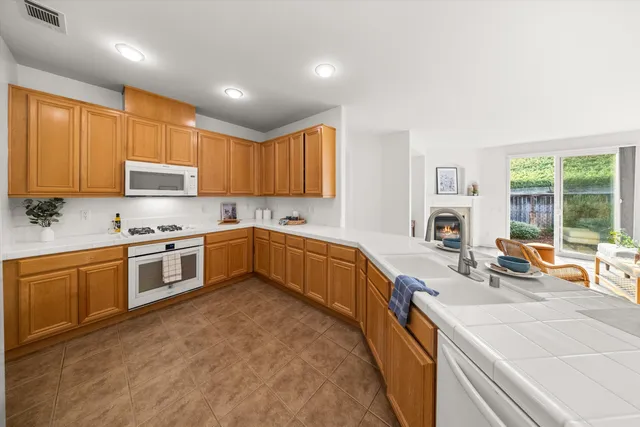 a kitchen with stainless steel appliances a stove top oven a sink a refrigerator and cabinets