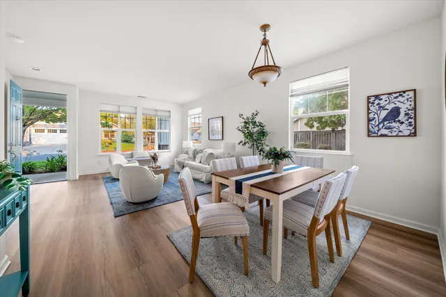 a dining room with furniture a chandelier and wooden floor