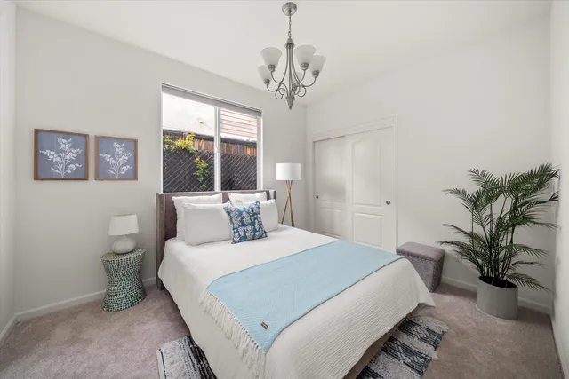 a bedroom with a large bed and a chandelier