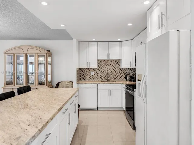 a kitchen with a refrigerator a sink and cabinets