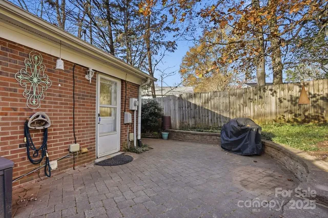 a backyard of a house with barbeque oven table and chairs
