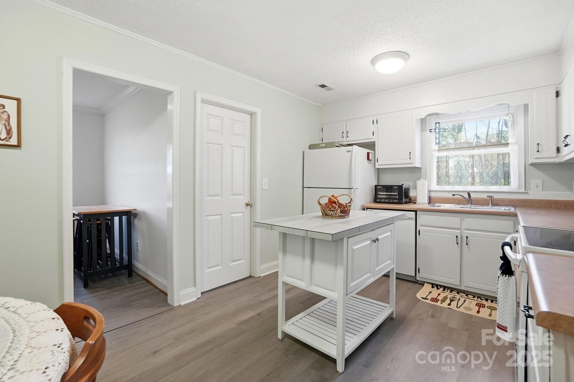 6309 Pineburr Road Charlotte, NC 28211 - Photo 40 of 46 a kitchen with a sink cabinets and wooden floor
