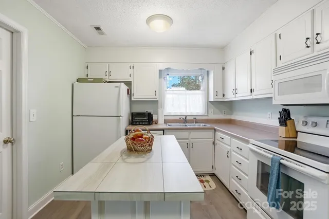 a view of a kitchen area with furniture and wooden floor