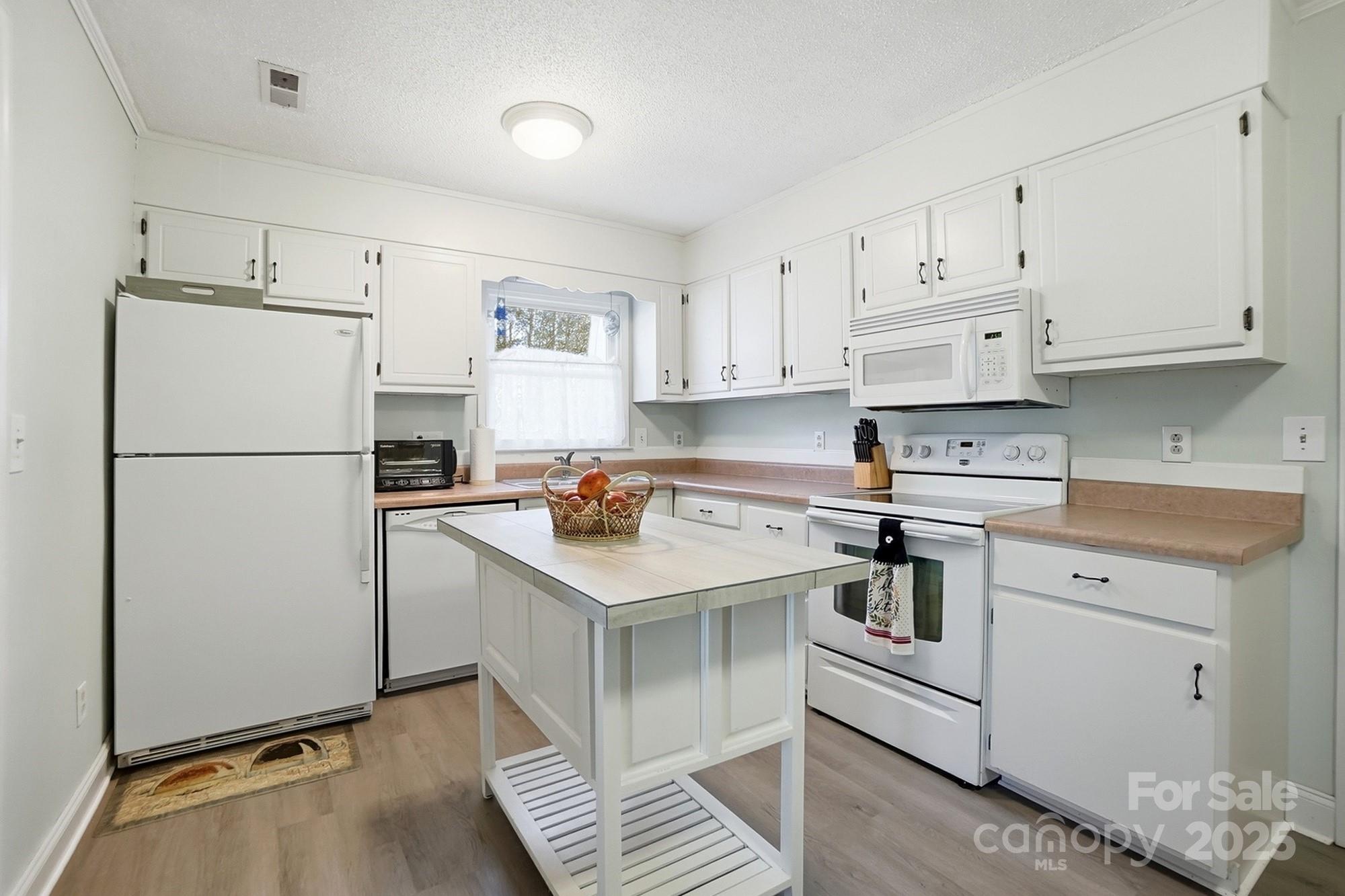 6309 Pineburr Road Charlotte, NC 28211 - Photo 42 of 46 a kitchen with white cabinets and white appliances