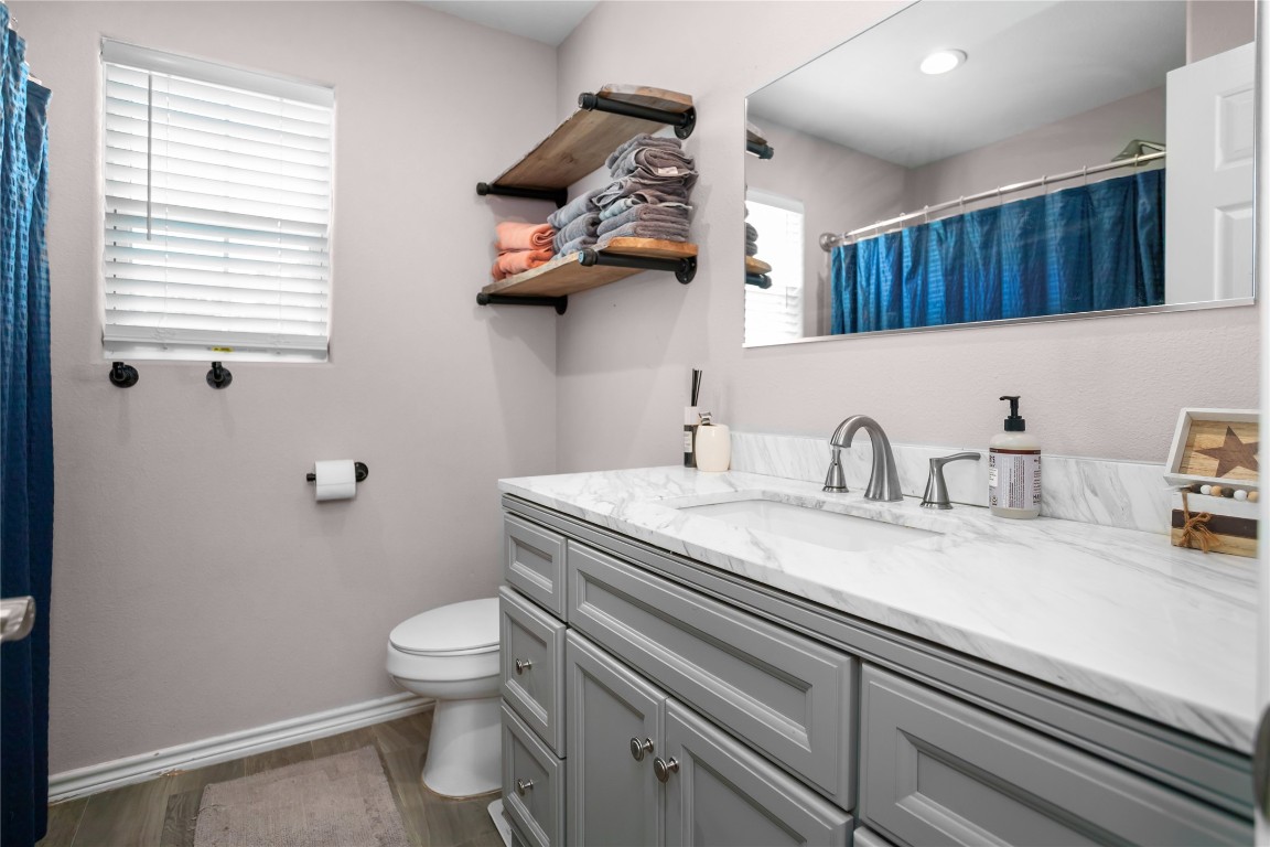 295 Garden City Road Livingston, TX 77351 - Photo 13 of 20 a bathroom with a granite countertop sink a toilet and a window