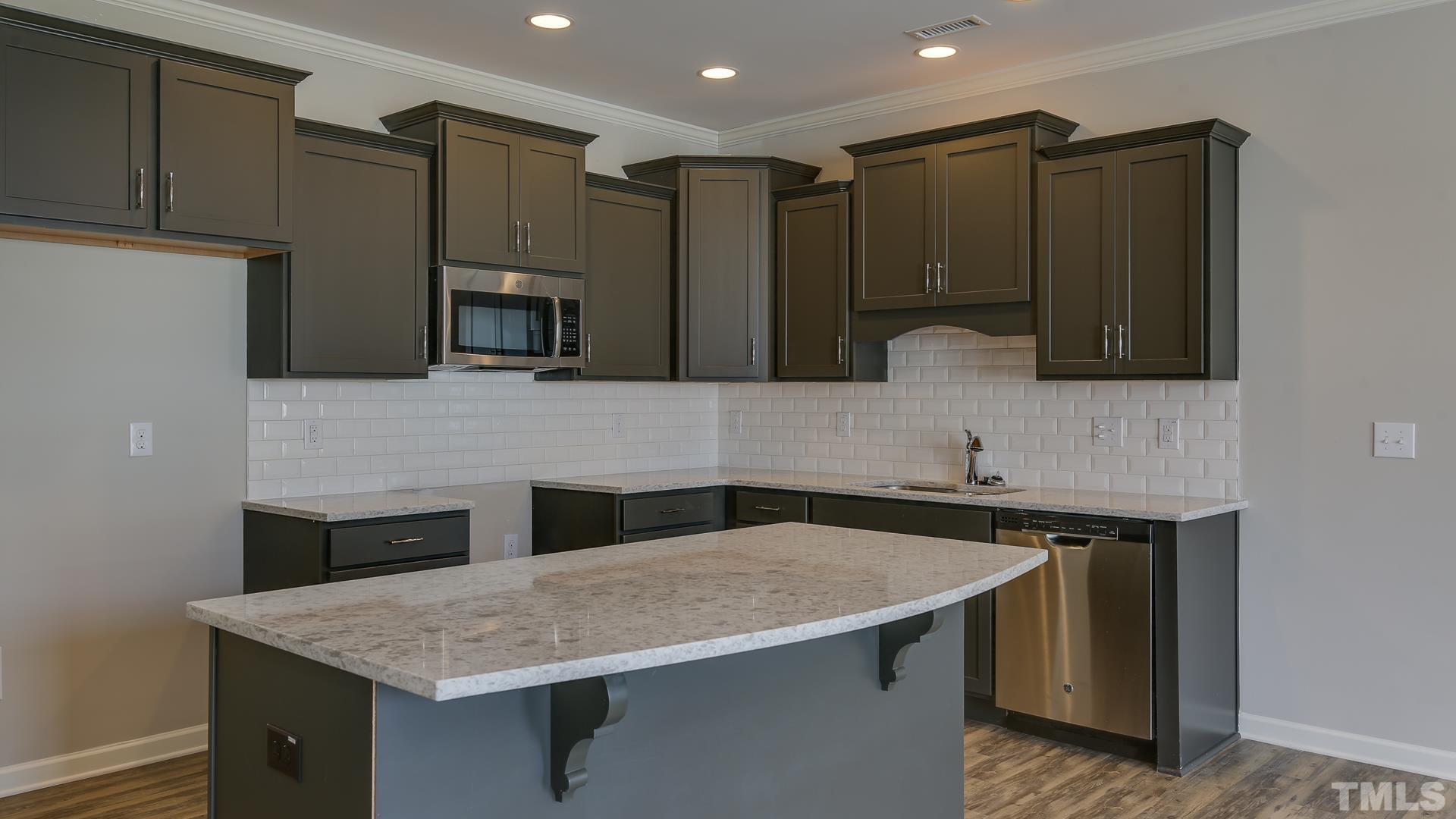 4819 Crescent Square Street, Unit 2409 Raleigh, NC 27616 - Photo 3 of 8 a kitchen with a sink dishwasher a stove and a refrigerator with wooden cabinets