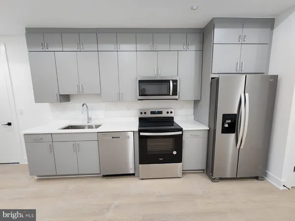 a kitchen with stainless steel appliances a refrigerator a stove a sink a microwave and cabinets