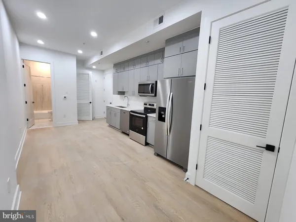 a kitchen with stainless steel appliances a refrigerator and a stove top oven