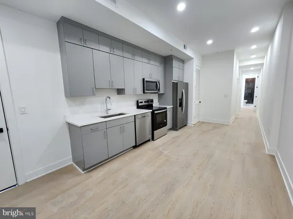 a kitchen with stainless steel appliances a sink a stove a refrigerator and cabinets