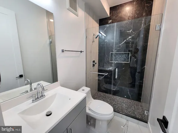 a bathroom with a sink toilet and shower