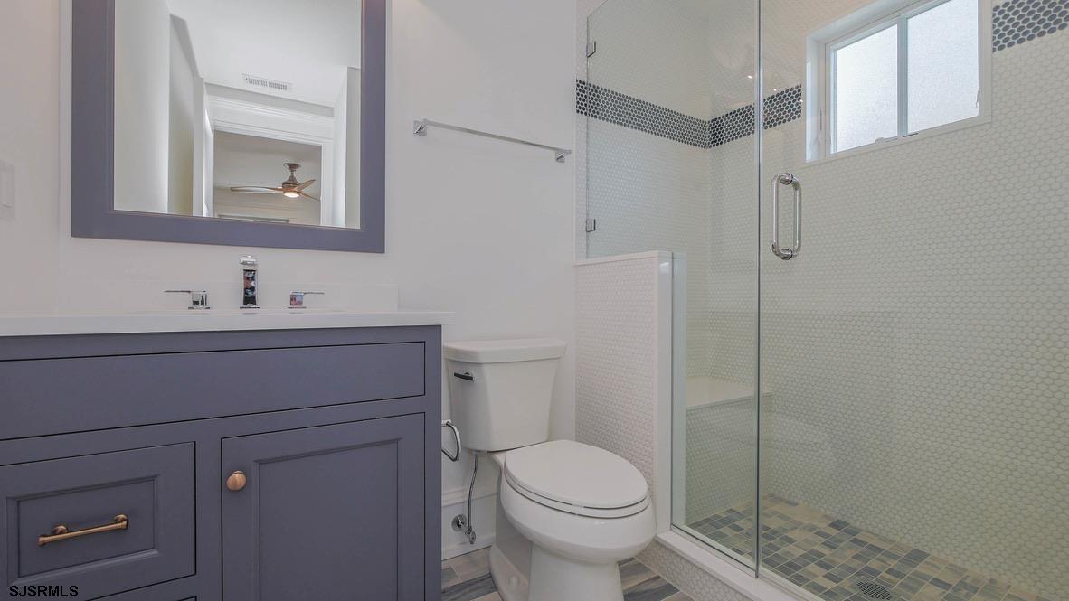 481 7th Street Avalon, NJ 08202 - Photo 24 of 51 a bathroom with a toilet sink vanity and mirror
