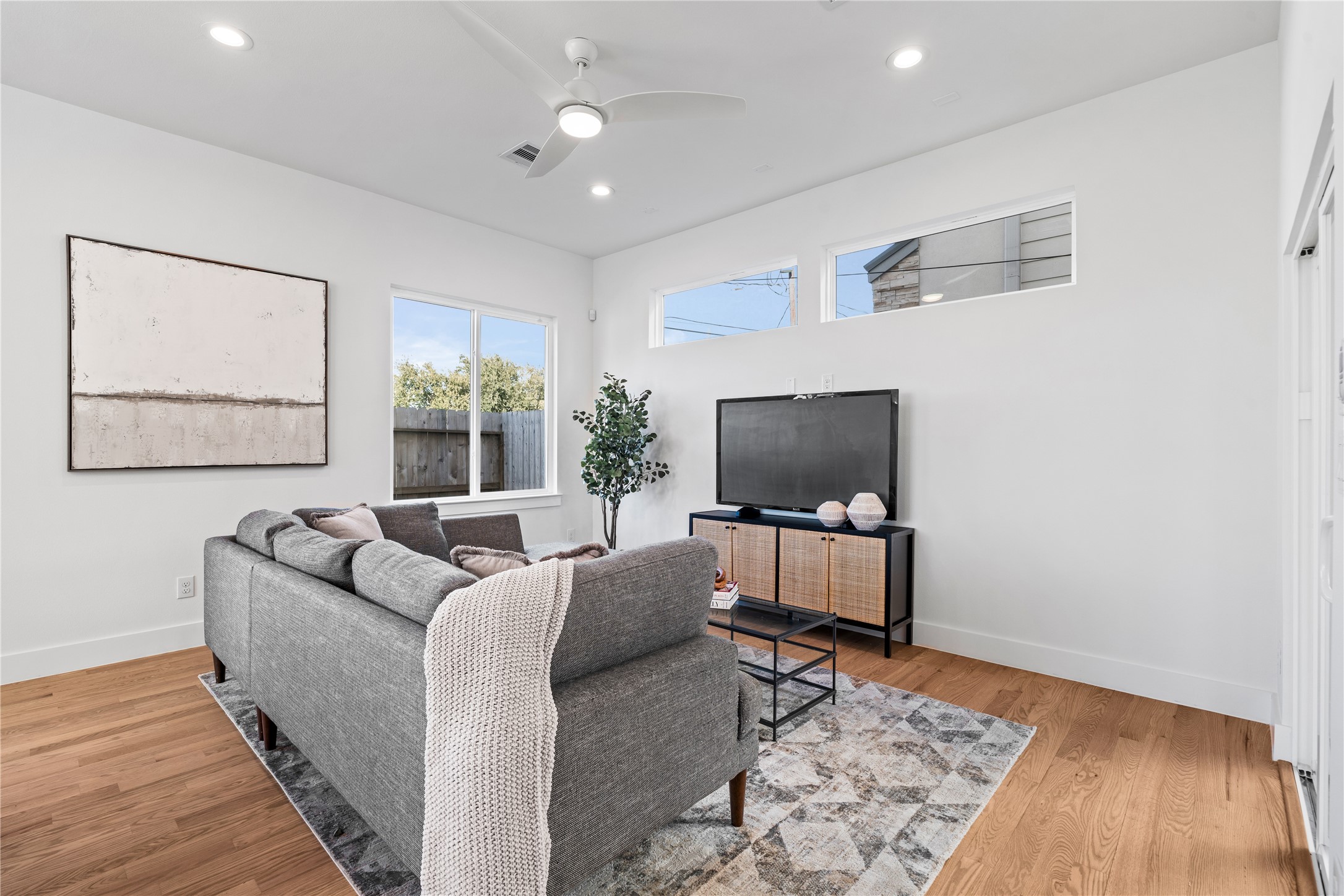 1810 Yates Street Houston, TX 77020 - Photo 13 of 30 Bright & inviting living room with clerestory windows, a modern ceiling fan & large sliding doors that open to the covered patio for effortless indoor-outdoor living.