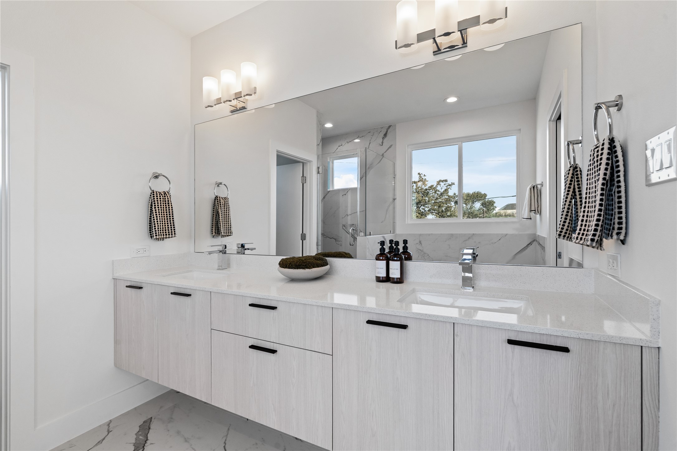 1810 Yates Street Houston, TX 77020 - Photo 20 of 30 Floating double vanity with ample storage, a large framed mirror & custom lighting that brings a touch of sophistication to the primary bath.