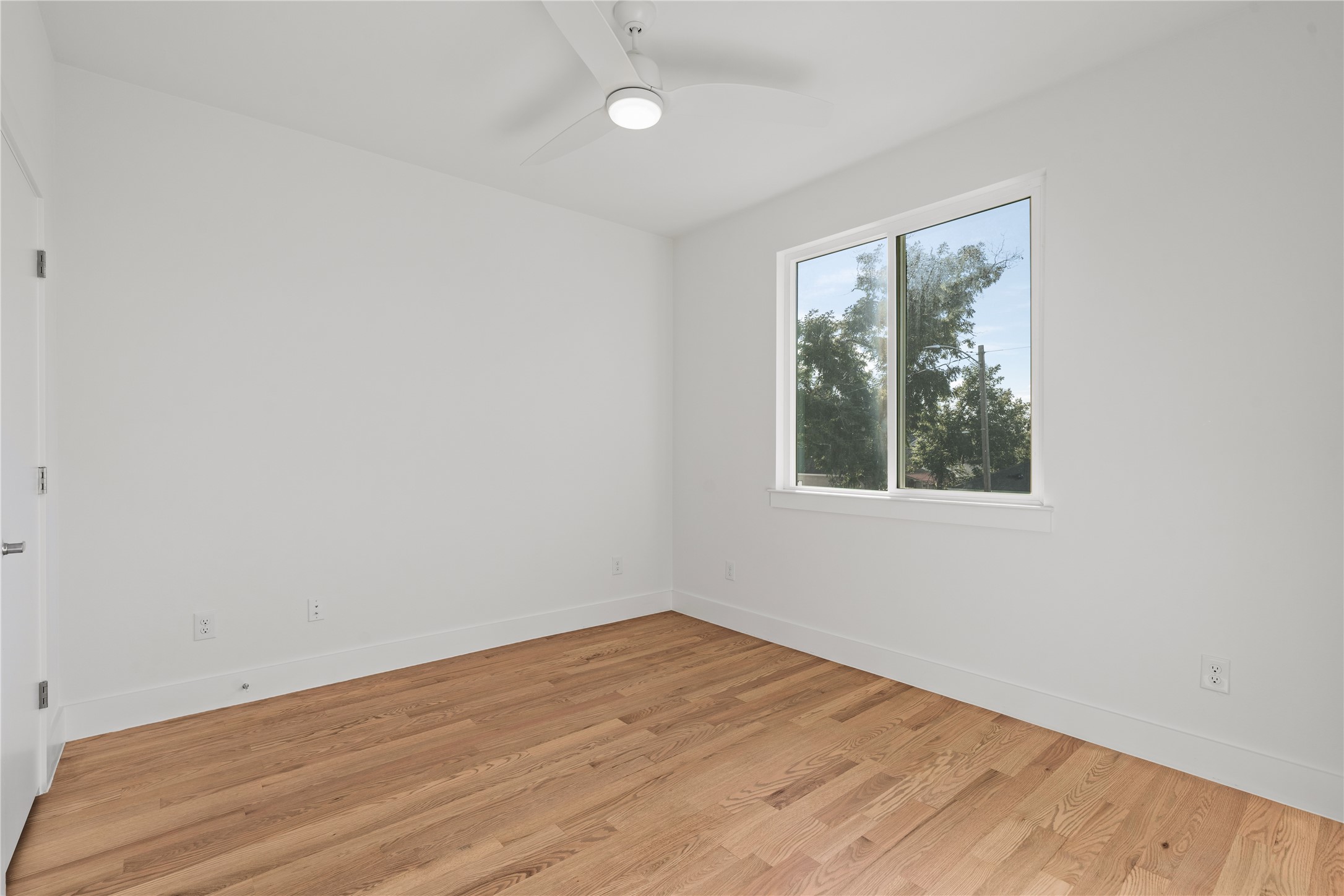 1810 Yates Street Houston, TX 77020 - Photo 23 of 30 Secondary bedroom with tall windows, ceiling fan and clean architectural lines.