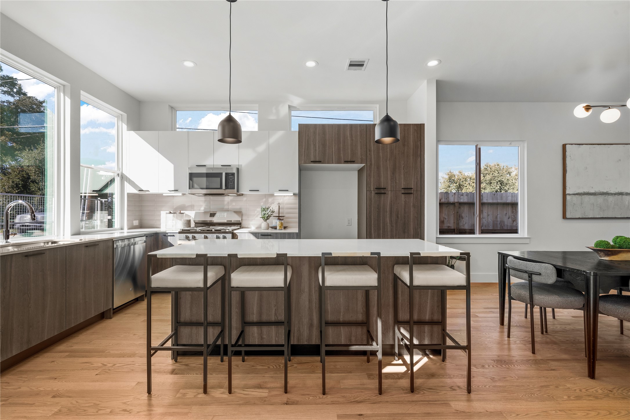 1810 Yates Street Houston, TX 77020 - Photo 4 of 30 Sunlit kitchen featuring two-tone European-style cabinetry, quartz countertops & stainless steel appliances, designed with a large island perfect for dining & entertaining.