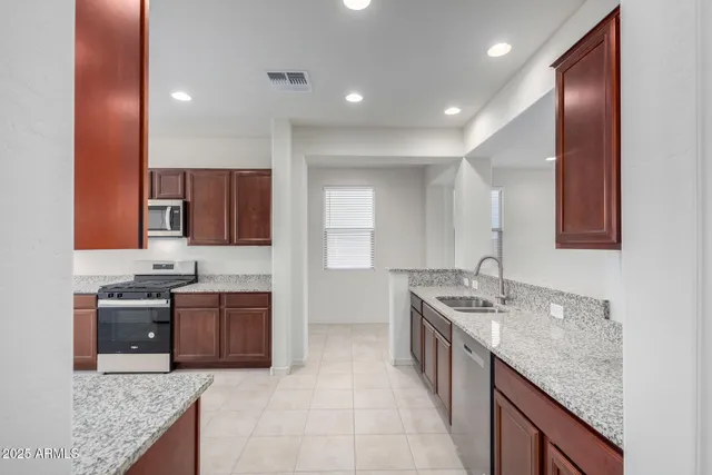 a kitchen with stainless steel appliances granite countertop a sink stove and cabinets