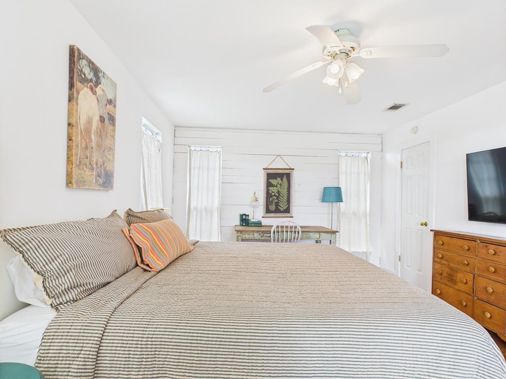 289 Kc 474 Harper, TX 78631 - Photo 20 of 27 a spacious bedroom with a bed a chandelier and a flat screen television