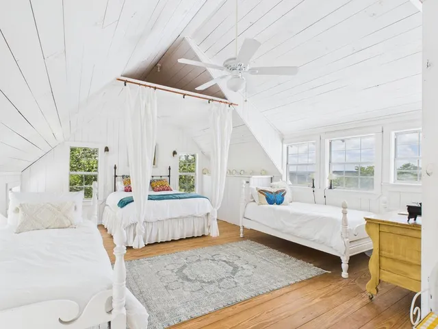 a bedroom with furniture and a large window