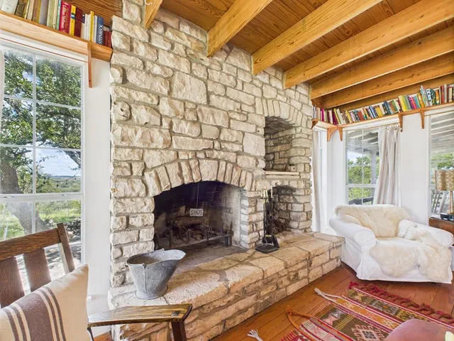 a living room with furniture a fireplace and a floor to ceiling window