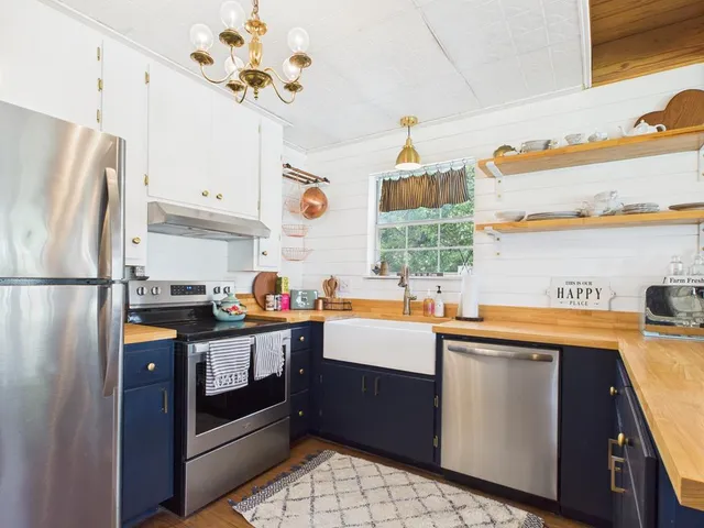 a kitchen with granite countertop a sink stainless steel appliances and cabinets