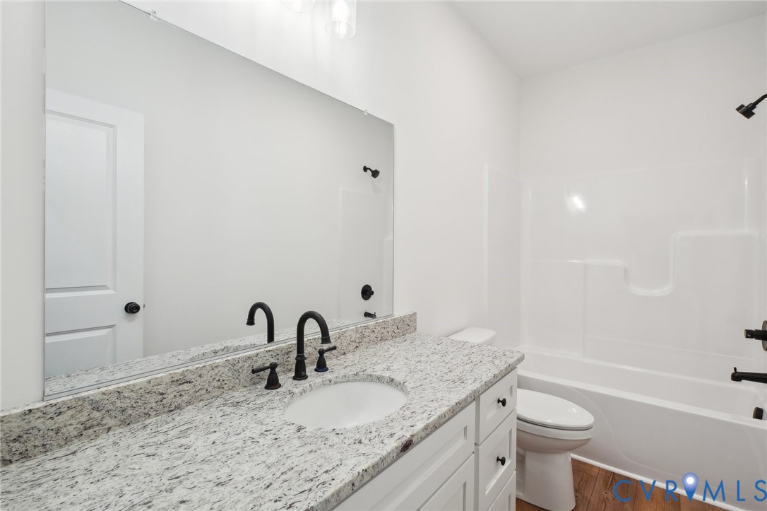 3520 Clintwood Road Midlothian, VA 23112 - Photo 26 of 32 a bathroom with a granite countertop sink a toilet and a bathtub