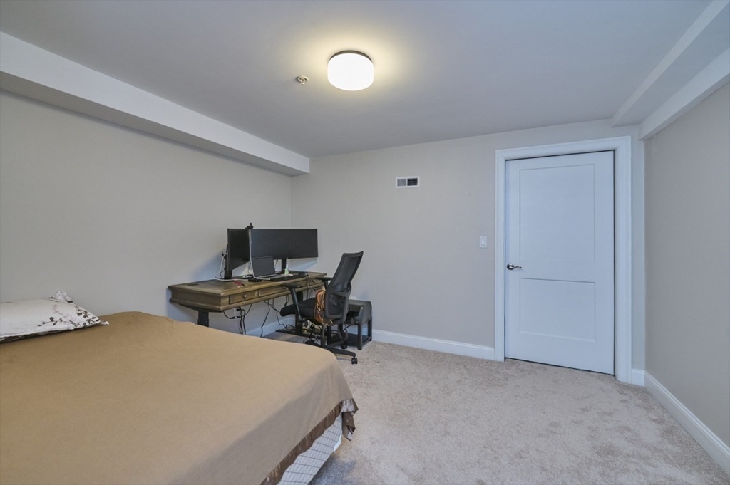 299 Lexington Street, Unit 51 Woburn, MA 01801 - Photo 16 of 37 a bedroom with a bed and chair