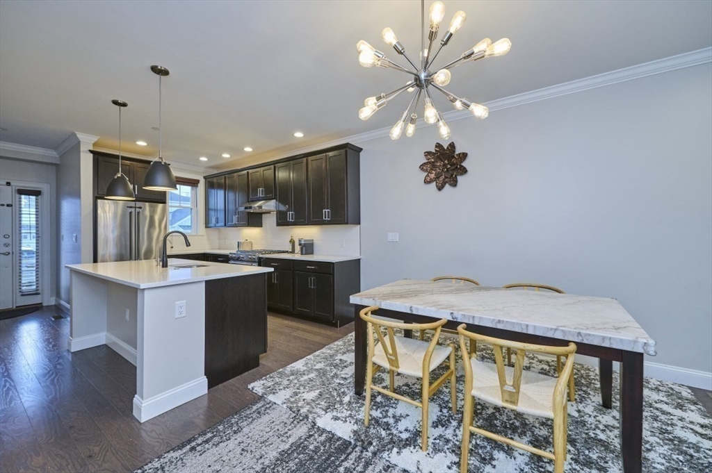 299 Lexington Street, Unit 51 Woburn, MA 01801 - Photo 2 of 37 a kitchen with kitchen island a sink stainless steel appliances and cabinets