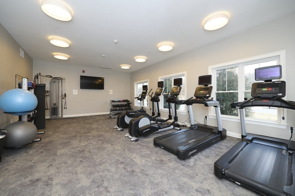 299 Lexington Street, Unit 51 Woburn, MA 01801 - Photo 29 of 37 a living room with furniture and a flat screen tv