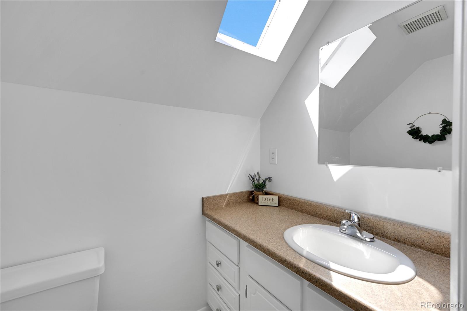 3709 Allison Street Wheat Ridge, CO 80033 - Photo 12 of 44 a bathroom with a granite countertop sink and a mirror