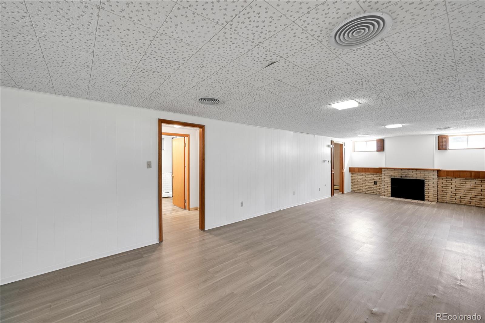 3709 Allison Street Wheat Ridge, CO 80033 - Photo 19 of 44 an empty room with wooden floor cabinet and windows