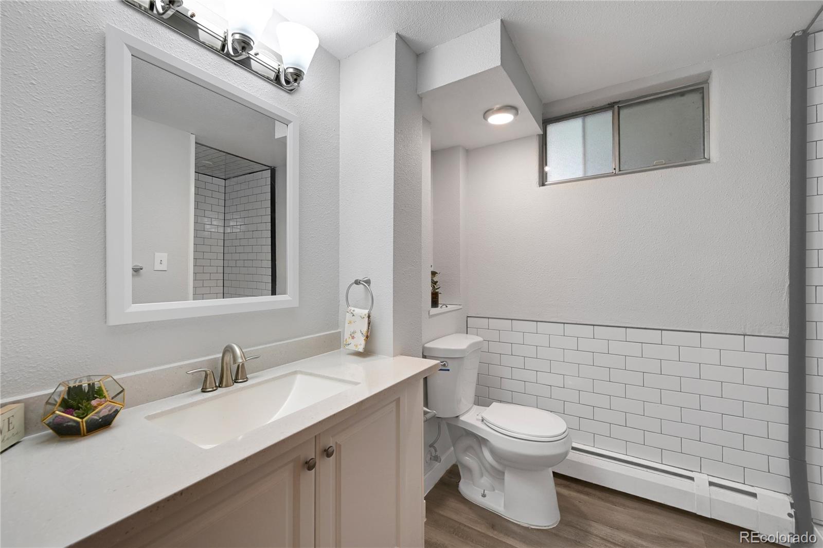 3709 Allison Street Wheat Ridge, CO 80033 - Photo 23 of 44 a bathroom with a toilet a sink and mirror