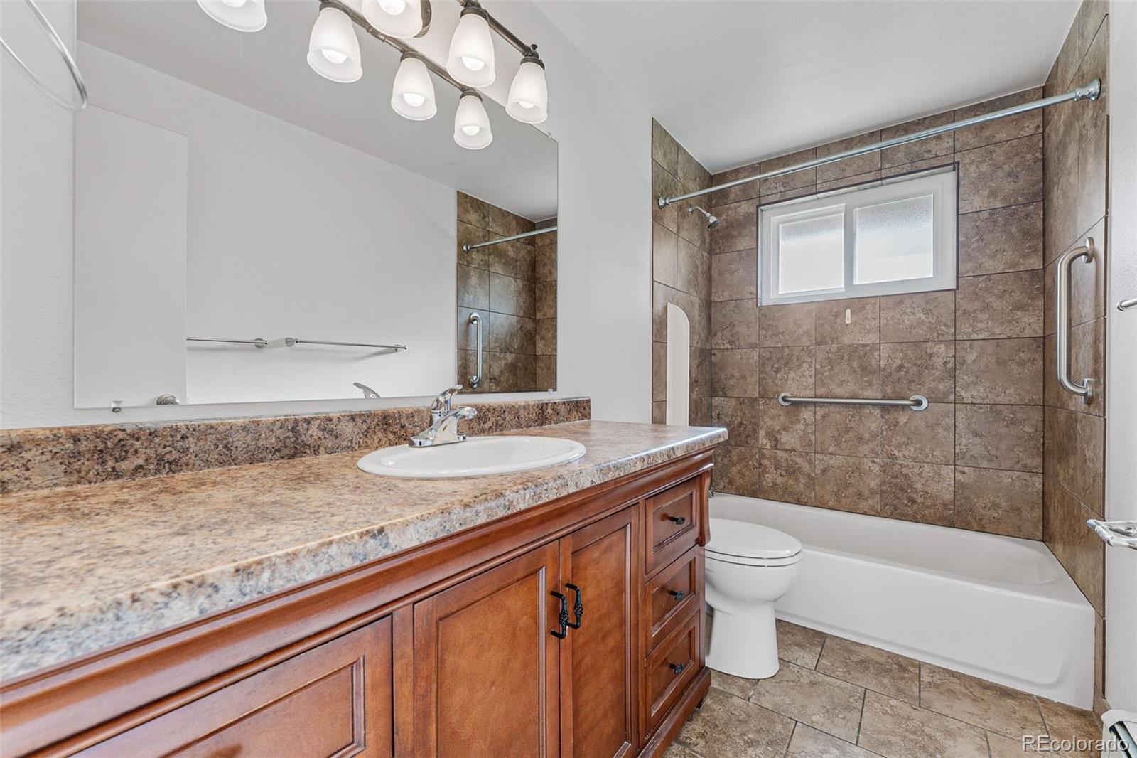 3709 Allison Street Wheat Ridge, CO 80033 - Photo 36 of 44 a bathroom with a granite countertop sink a toilet and bathtub