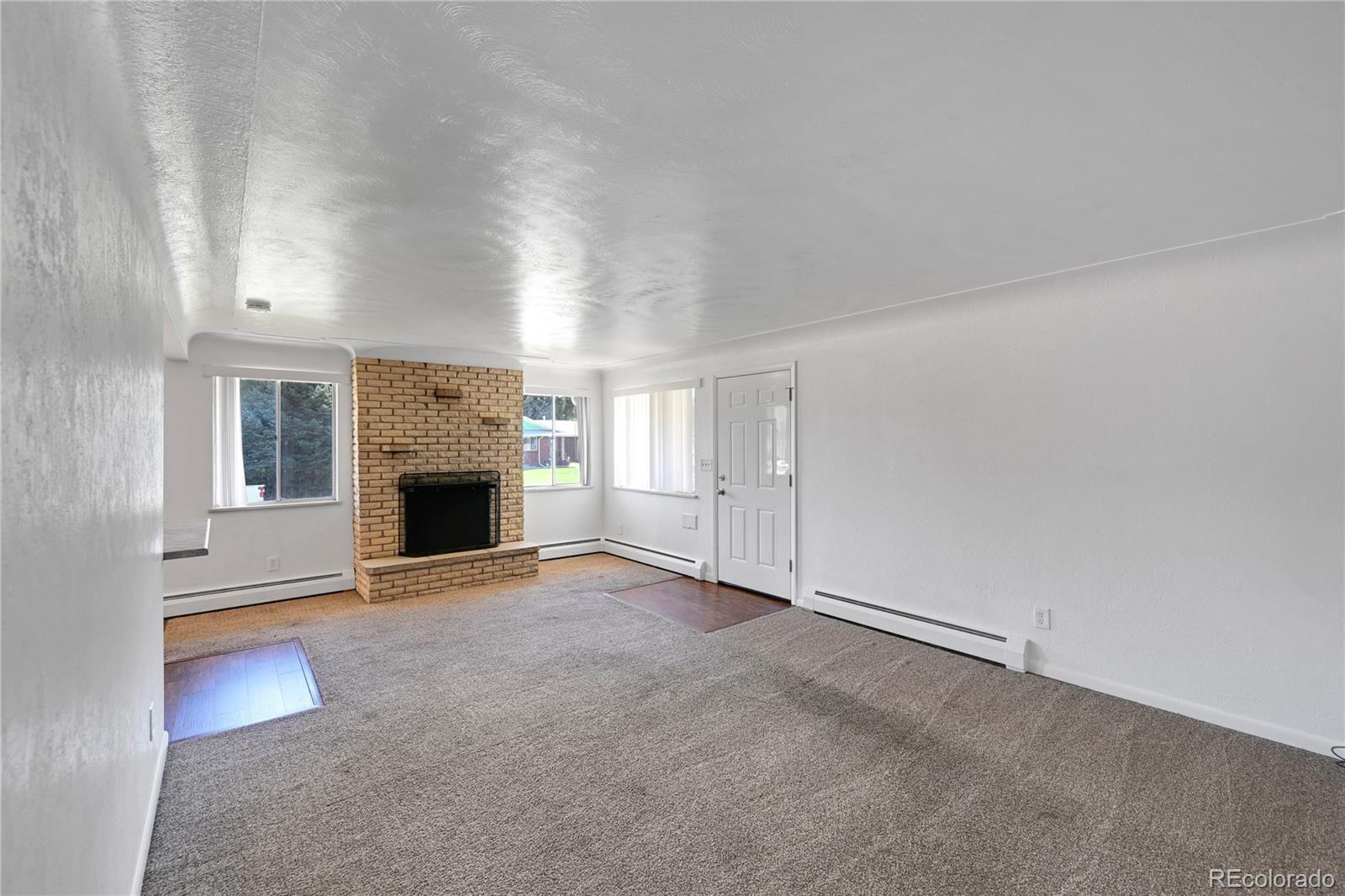 3709 Allison Street Wheat Ridge, CO 80033 - Photo 4 of 44 an empty room with fireplace and windows