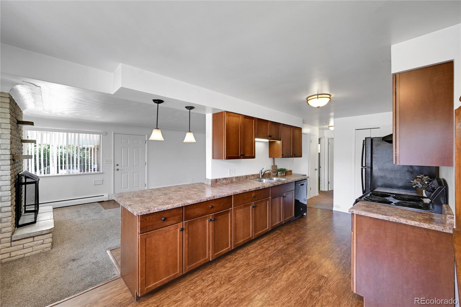 3709 Allison Street Wheat Ridge, CO 80033 - Photo 6 of 44 a kitchen with stainless steel appliances granite countertop a stove a sink and a microwave
