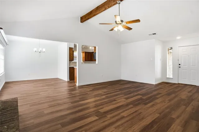a view of a livingroom with wooden floor and a ceiling fan
