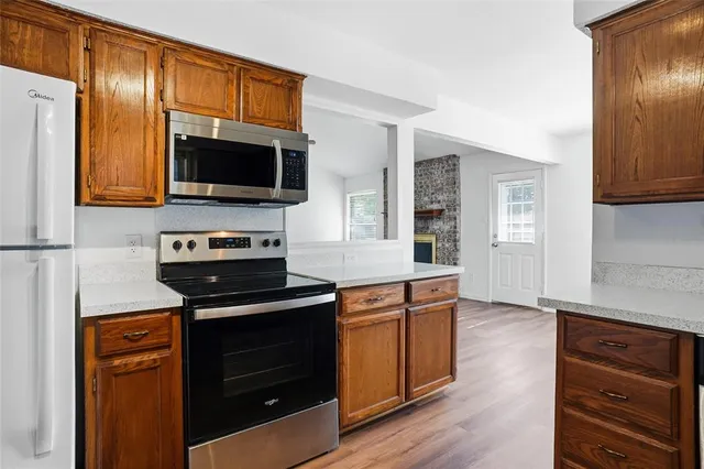 a kitchen with stainless steel appliances a stove a microwave and sink