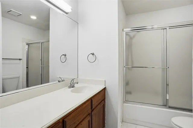 a bathroom with a shower sink vanity and mirror