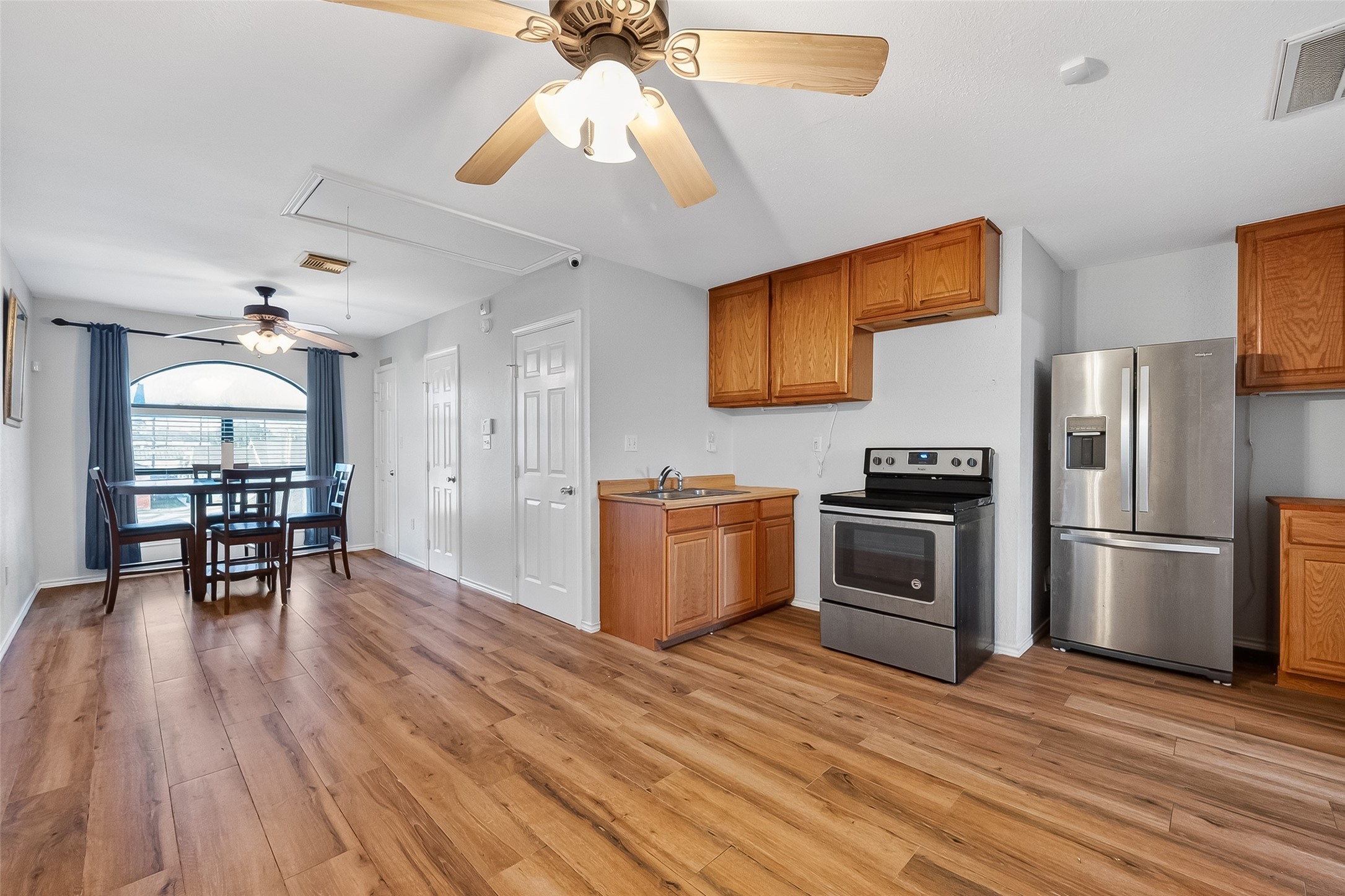 512 Bertloma Street Pasadena, TX 77502 - Photo 33 of 48 a kitchen with granite countertop a stove a refrigerator and a dining table with wooden floor