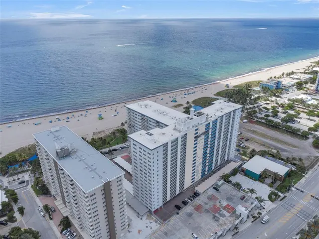 a view of swimming pool with lawn chairs and wooden fence