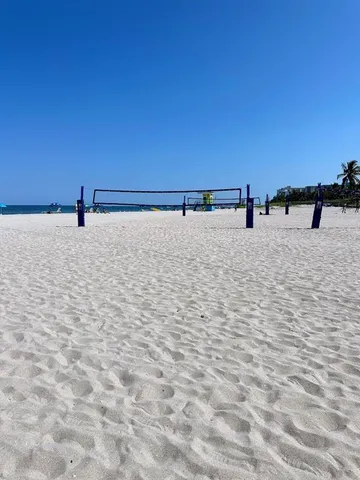 a view of a swimming pool with lawn chairs under an umbrella