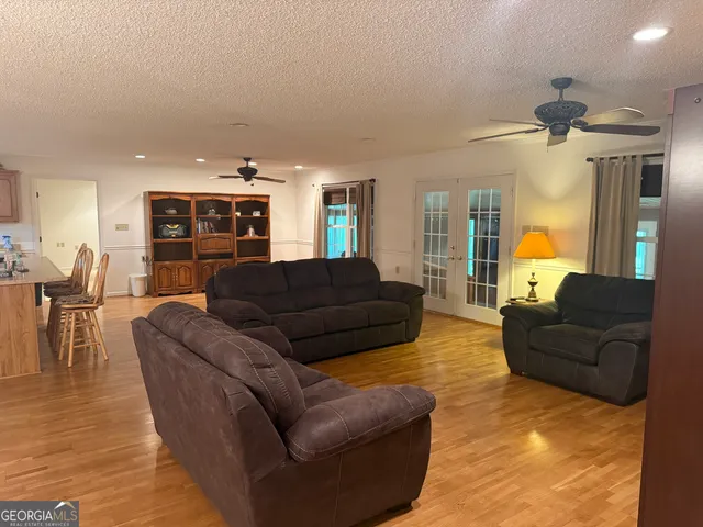 a living room with furniture and a dining table with kitchen view