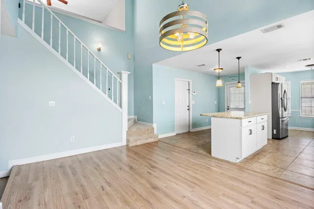 a view of a kitchen with wooden floor and a chandelier