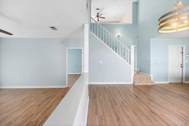 a view of a hallway with wooden floor and staircase