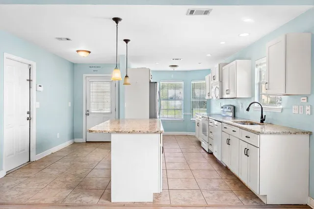 a kitchen with stainless steel appliances kitchen island granite countertop a sink and cabinets