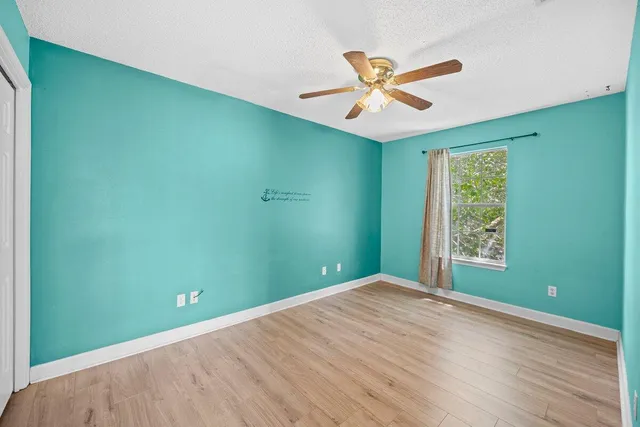 a view of a big room with window and a ceiling fan