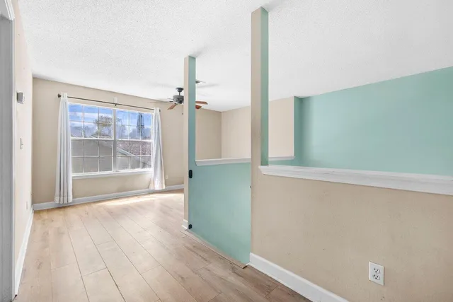 an empty room with wooden floor and a window